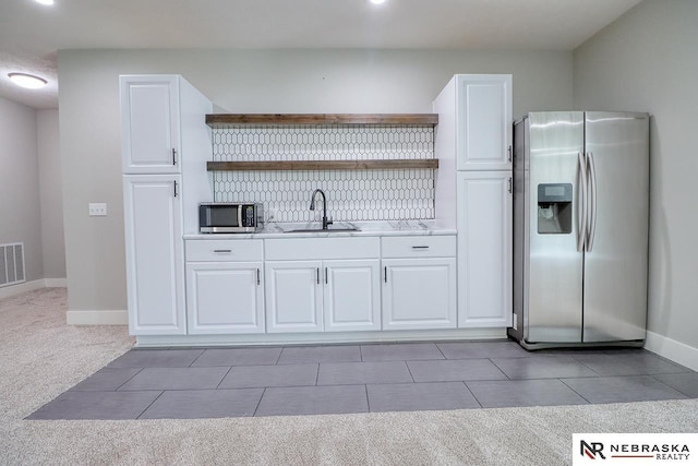 kitchen with white cabinetry, sink, carpet floors, and appliances with stainless steel finishes