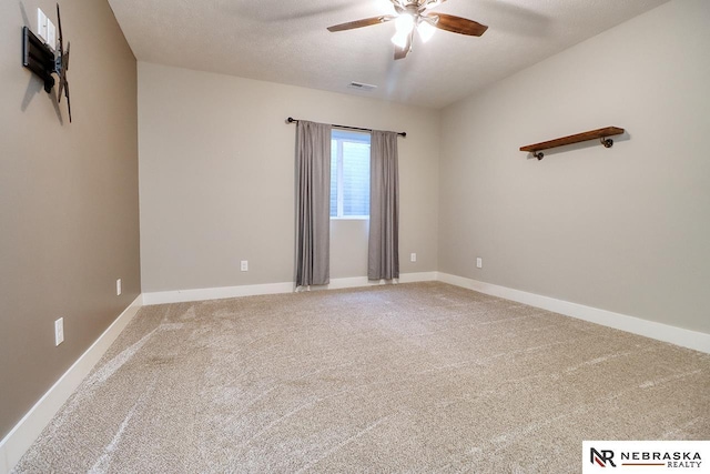 spare room featuring carpet, a textured ceiling, and ceiling fan