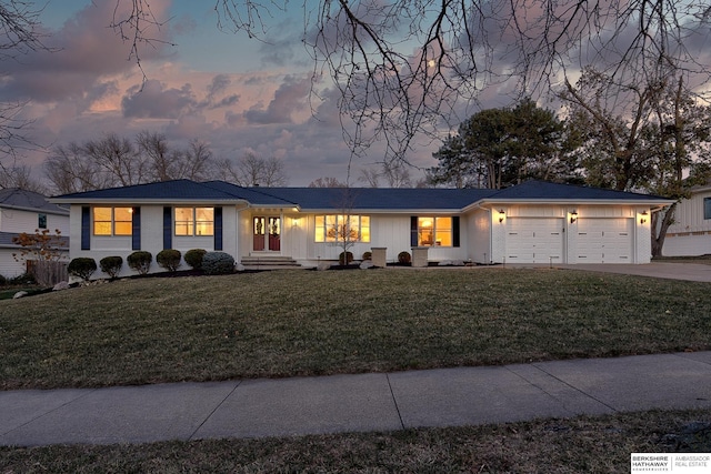 ranch-style house with a lawn and a garage