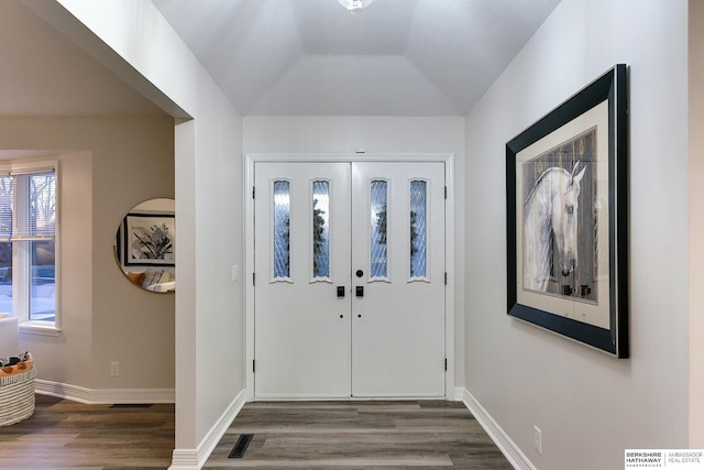 foyer with dark hardwood / wood-style floors and lofted ceiling