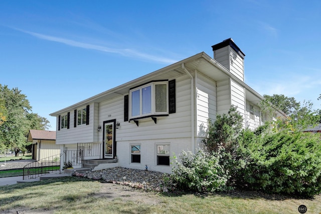 split foyer home with a front lawn