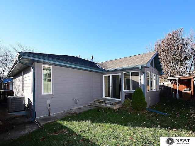 back of house with a yard and central AC unit