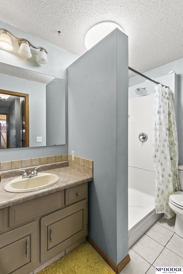 bathroom featuring a shower with shower curtain, vanity, a textured ceiling, and tile patterned flooring