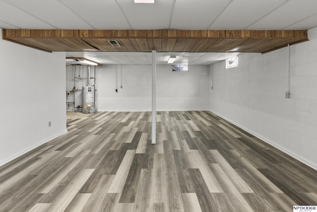 basement featuring hardwood / wood-style floors and gas water heater