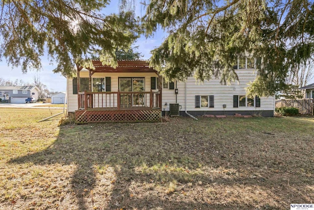 rear view of property with cooling unit, a yard, and a wooden deck