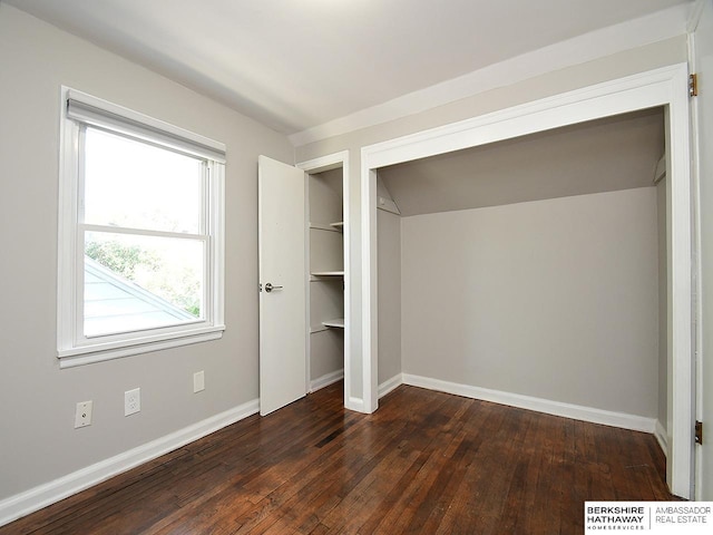 unfurnished bedroom featuring dark hardwood / wood-style flooring and a closet