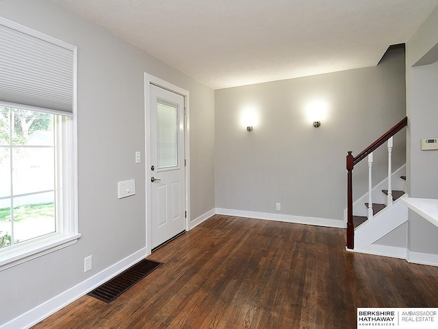 entryway with a healthy amount of sunlight and dark hardwood / wood-style floors