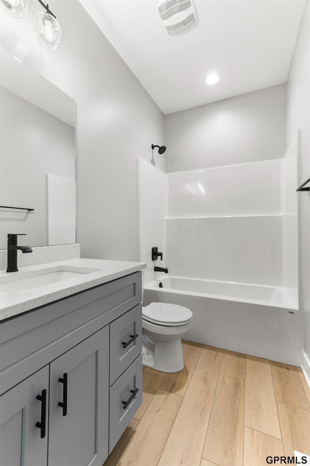 full bathroom featuring bathing tub / shower combination, toilet, vanity, and hardwood / wood-style flooring