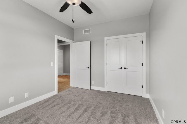 unfurnished bedroom with carpet, a closet, and ceiling fan