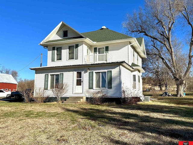 view of front of home featuring a balcony and a front yard