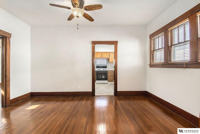 unfurnished room with dark hardwood / wood-style flooring and ceiling fan