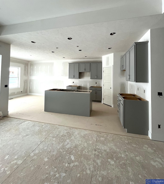 kitchen featuring a textured ceiling and gray cabinetry