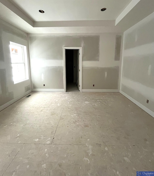 unfurnished room with a raised ceiling