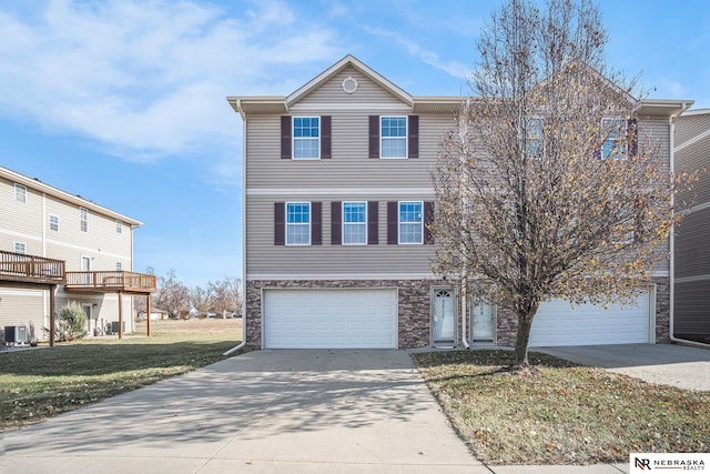 view of front of home with a garage, central air condition unit, and a front yard