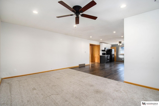 unfurnished living room with ceiling fan and dark hardwood / wood-style flooring