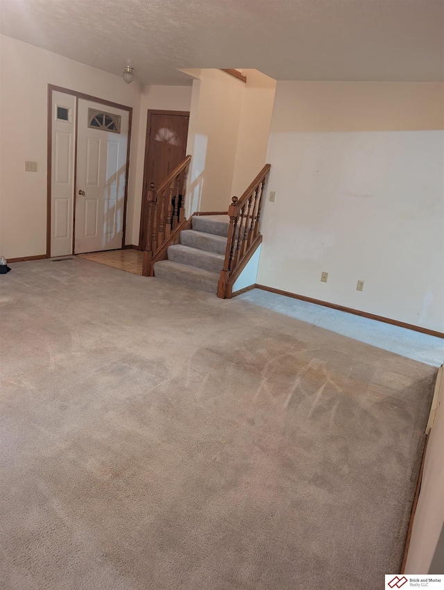 interior space with light colored carpet and a textured ceiling