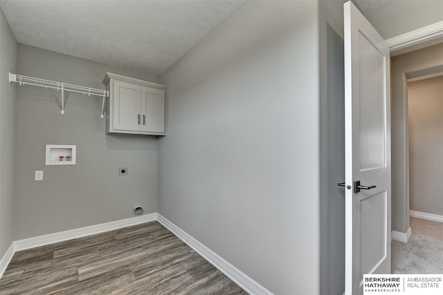 laundry room with cabinets, electric dryer hookup, hookup for a washing machine, wood-type flooring, and a textured ceiling