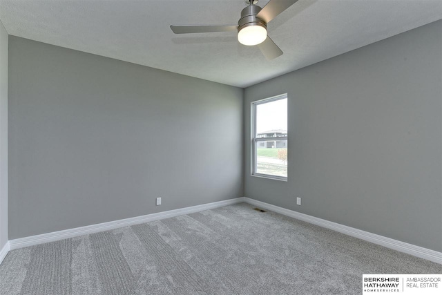 carpeted spare room with ceiling fan