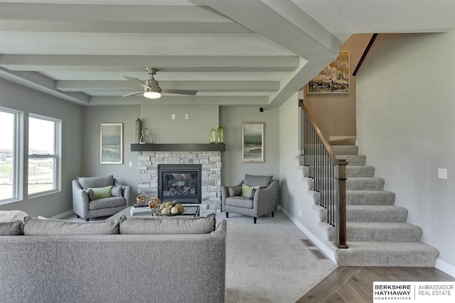 living room featuring beamed ceiling, ceiling fan, wood-type flooring, and a fireplace