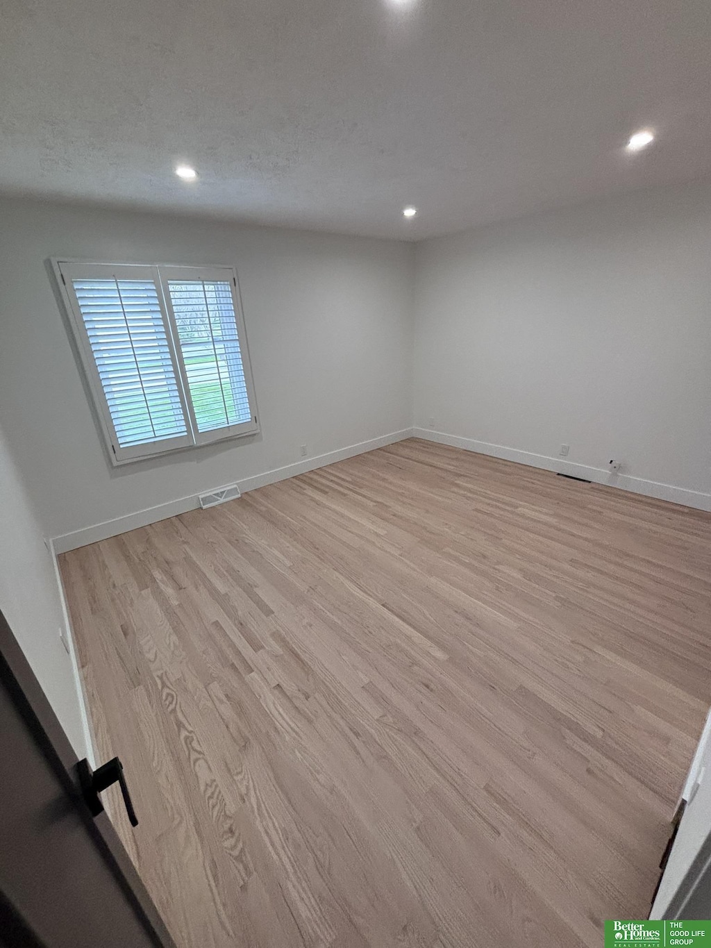 unfurnished room featuring a textured ceiling and light hardwood / wood-style flooring