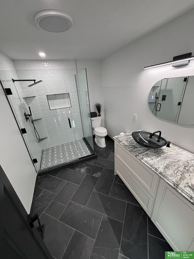 bathroom with an enclosed shower, vanity, and toilet