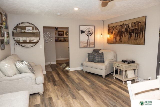 living room featuring a textured ceiling, ceiling fan, and dark hardwood / wood-style floors