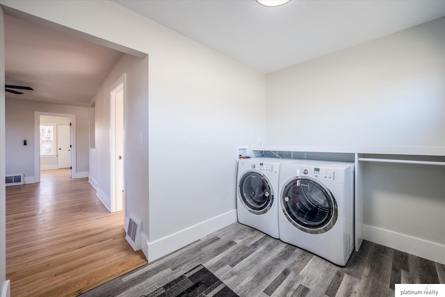 clothes washing area featuring hardwood / wood-style flooring, ceiling fan, and washing machine and clothes dryer