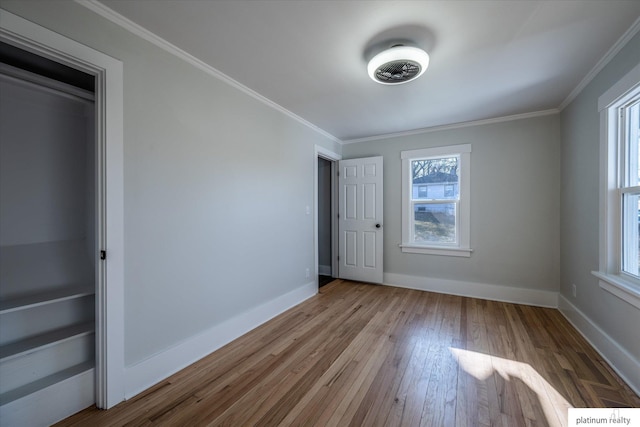 unfurnished bedroom with light hardwood / wood-style floors, crown molding, and a closet