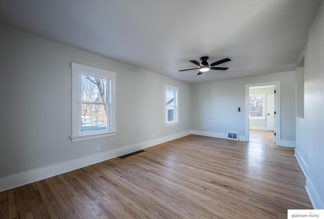 spare room featuring light hardwood / wood-style flooring, a wealth of natural light, and ceiling fan