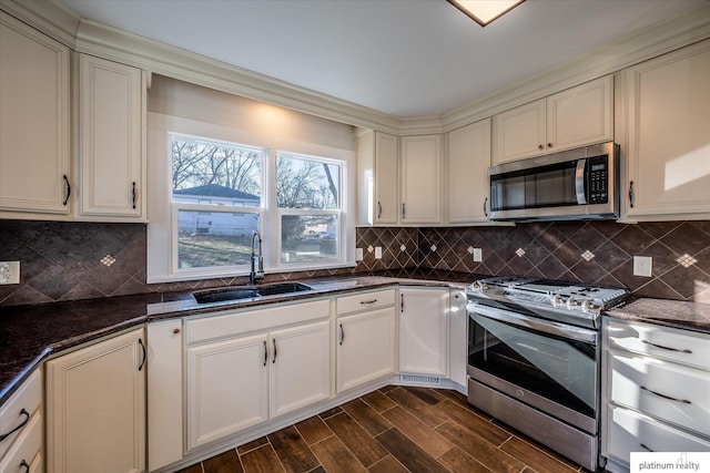 kitchen featuring sink, stainless steel appliances, dark hardwood / wood-style flooring, backsplash, and dark stone countertops