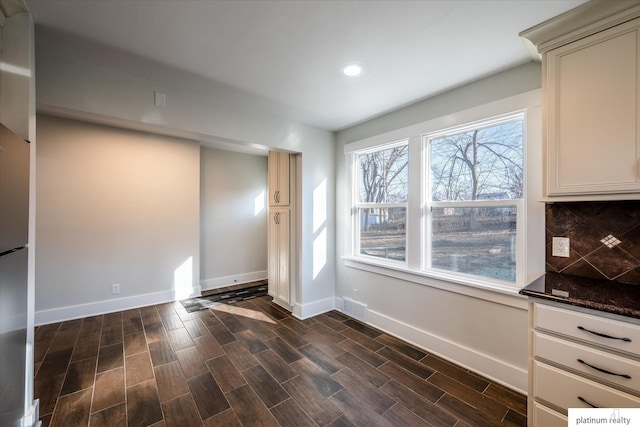 unfurnished dining area with dark wood-type flooring