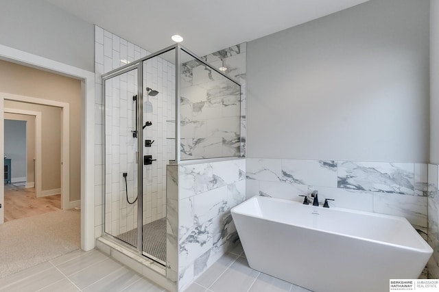 bathroom featuring tile patterned floors, tile walls, and independent shower and bath