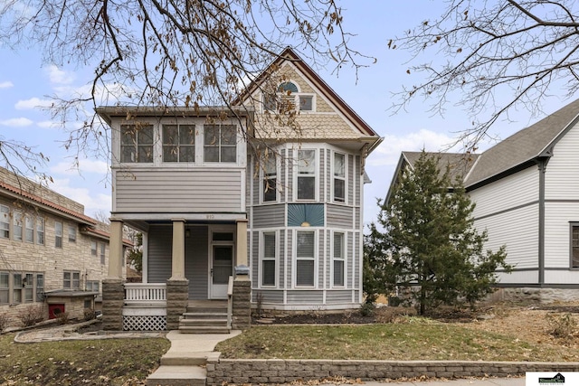 view of front facade with a sunroom, a porch, and a front yard