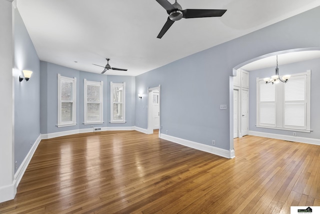 unfurnished living room with wood-type flooring and ceiling fan with notable chandelier