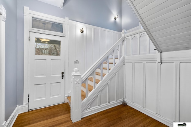 staircase featuring lofted ceiling and hardwood / wood-style flooring