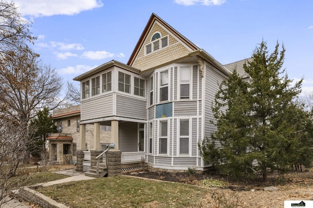 victorian home with a sunroom and a front yard