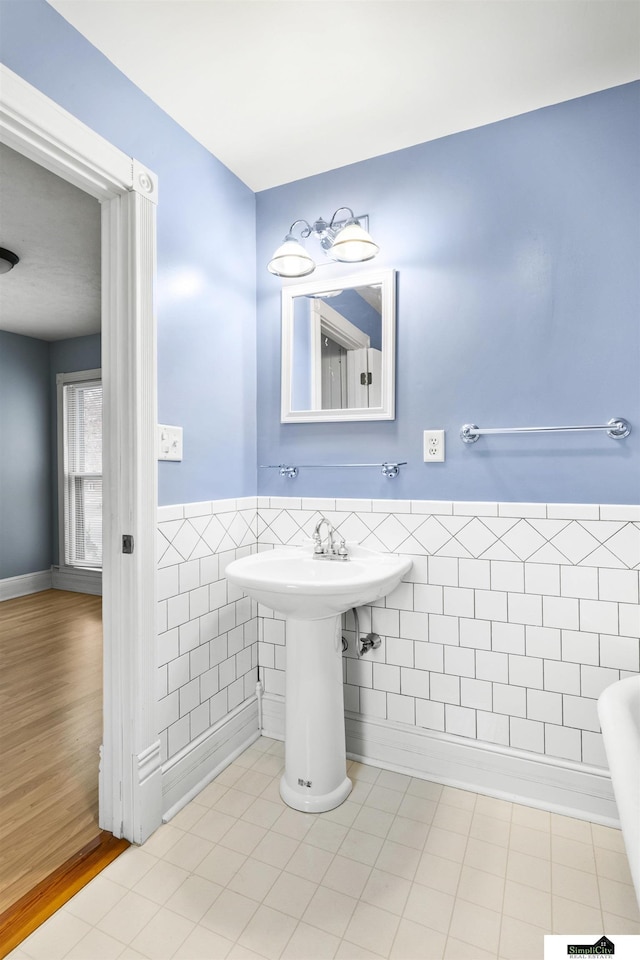 bathroom with hardwood / wood-style floors and tile walls