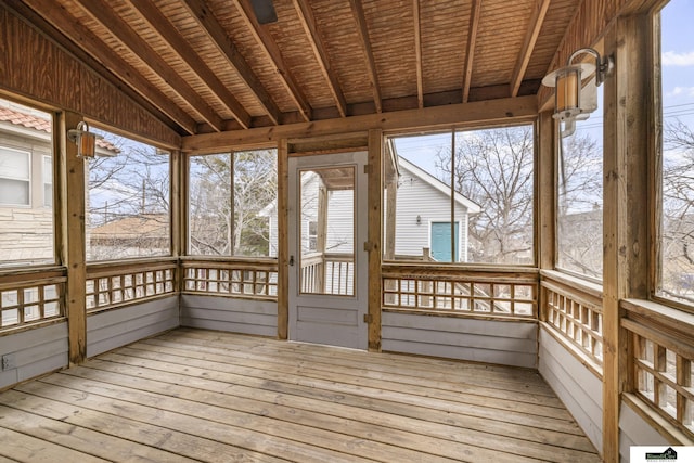 unfurnished sunroom with wood ceiling, a healthy amount of sunlight, and lofted ceiling