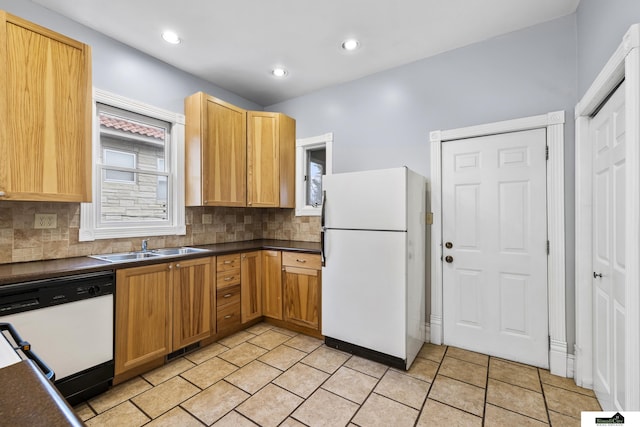 kitchen with decorative backsplash, sink, and white appliances