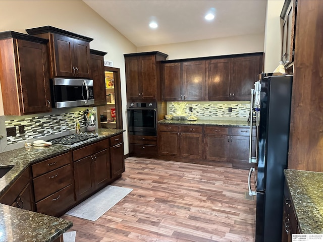 kitchen featuring tasteful backsplash, black appliances, lofted ceiling, and light wood-type flooring