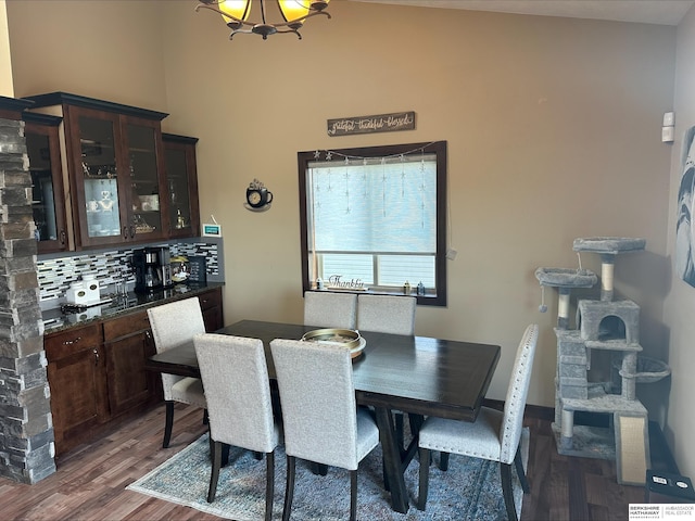 dining room featuring vaulted ceiling, dark hardwood / wood-style floors, and an inviting chandelier