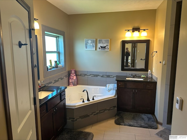 bathroom featuring tile patterned floors, tiled tub, and vanity