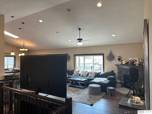 living room featuring a fireplace, wood-type flooring, lofted ceiling, and a textured ceiling