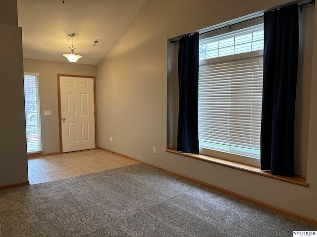 foyer entrance featuring light carpet and vaulted ceiling