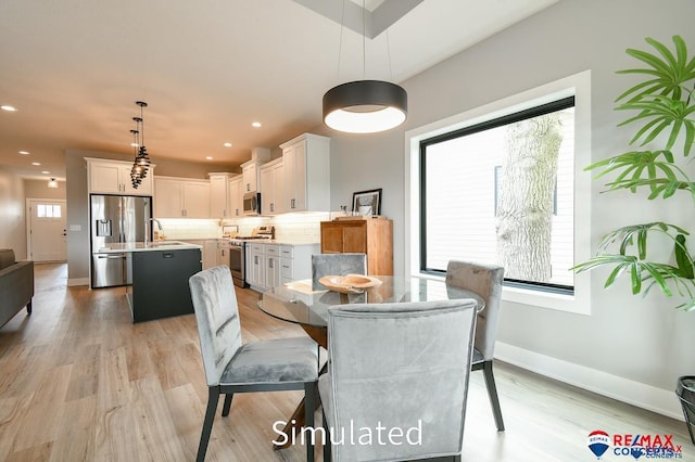 dining area featuring light hardwood / wood-style flooring and sink