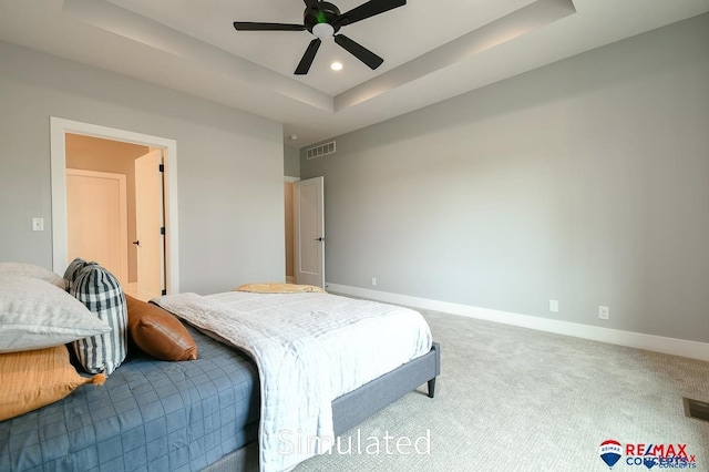 bedroom featuring a tray ceiling, ceiling fan, and carpet flooring