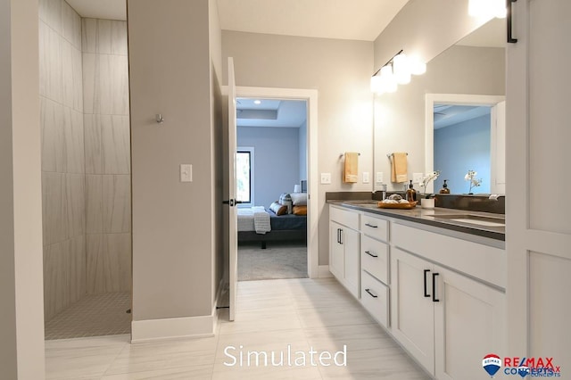 bathroom featuring tile patterned floors, vanity, and a tile shower