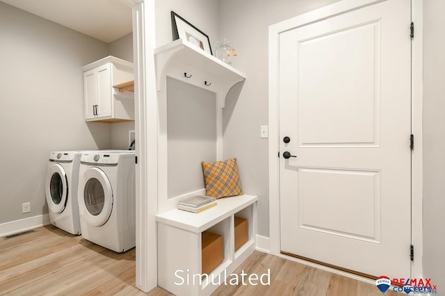 laundry room with cabinets, light hardwood / wood-style floors, and separate washer and dryer