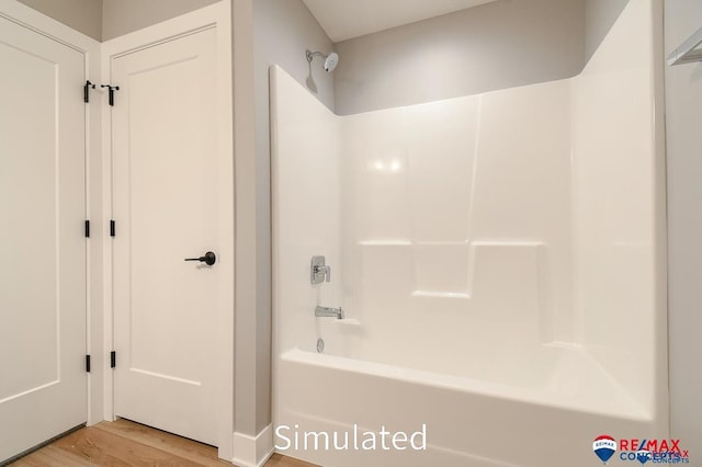 bathroom featuring hardwood / wood-style flooring and shower / washtub combination