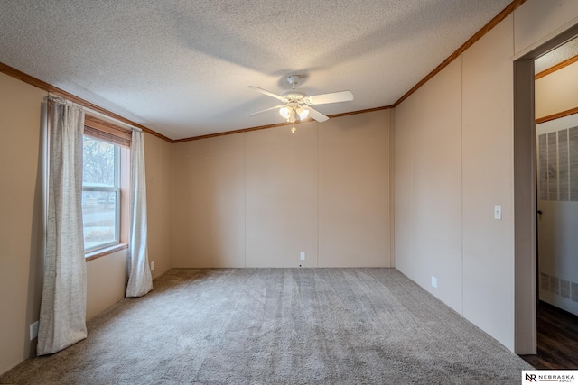 carpeted spare room with a textured ceiling, ceiling fan, and crown molding